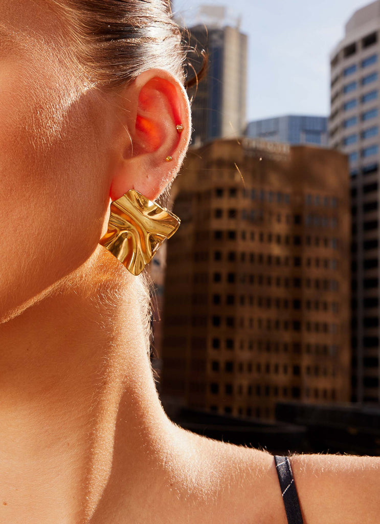 Womens Statement Fold Earrings in the colour Gold in front of a light grey background