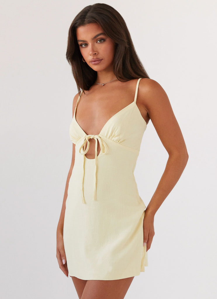 Womens Flora Linen Mini Dress in the colour Lemon in front of a light grey background